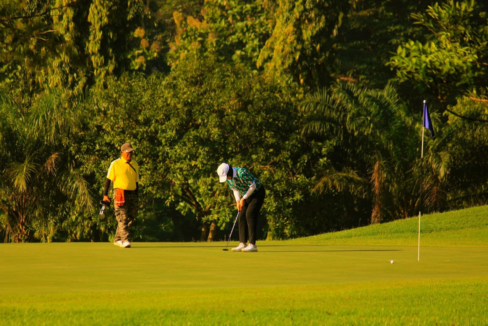 Two golfers on a sunny green
